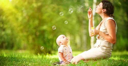 Mother blowing bubbles for her child